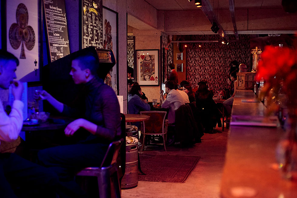 Ambiance chaleureuse et animée d'un bar-restaurant la nuit, clientèle attablée, décor rétro rouge et bleu, Lyon