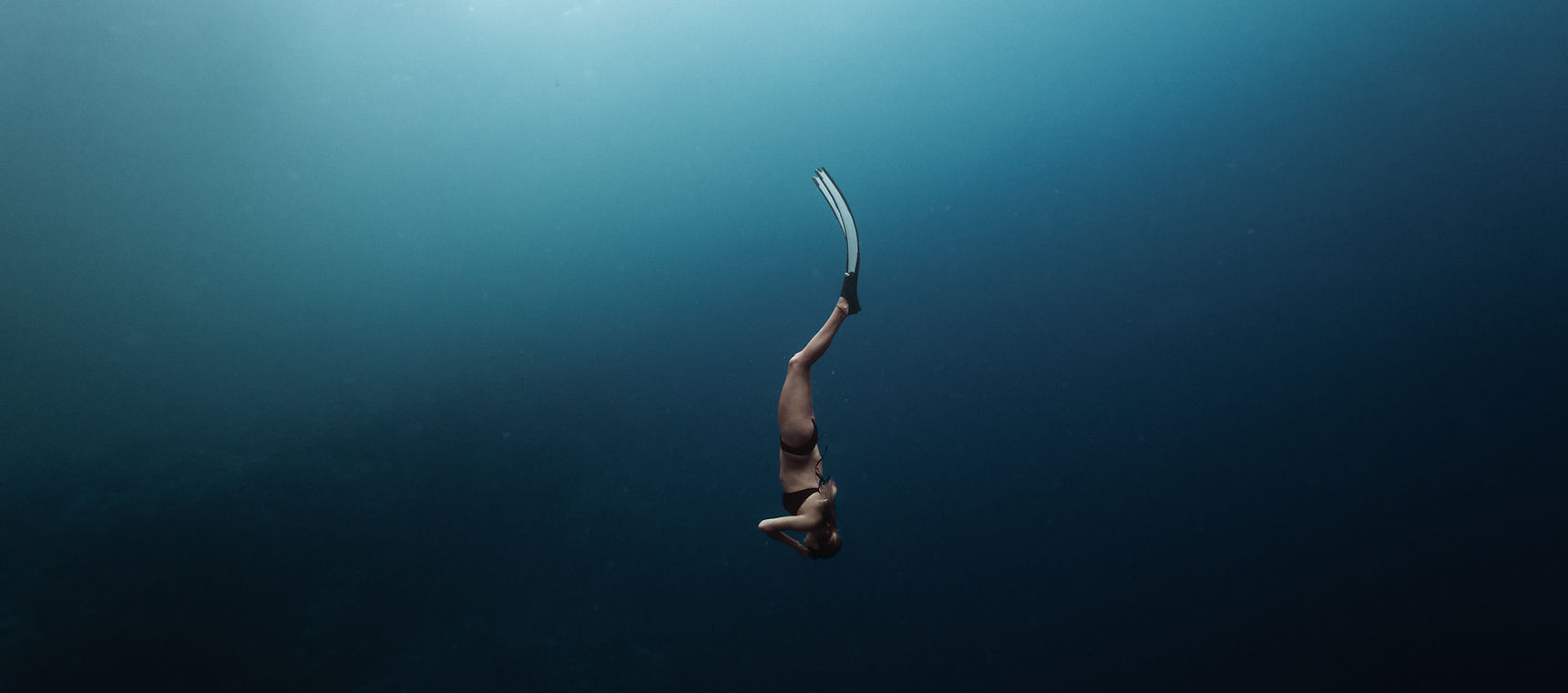 Freediver descending into the deep blue off the coast of Lefkada, Greece – capturing the essence of exploration and calm with Freedive Lefkada.