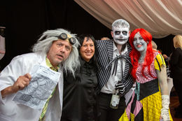 Four people in Halloween costumes posing together.
