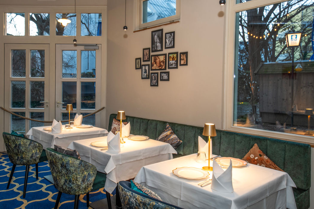 Restaurant dining room with white linens and green booths