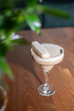 Creamy cocktail with a cookie garnish on a wooden table