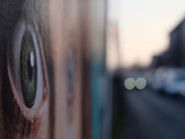 Modern art photo of an eye on a poster and car lights in blurry background | Photo: Achim Hennecke