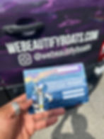 A hand holding a $2500 gift voucher from We Beautify Boats, with a branded van in the background displaying the website and Instagram handle @webeautifyboats.