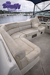 Faded and sun-worn vinyl seating inside a boat cockpit at a marina, showing discoloration and surface wear prior to professional vinyl recoloring by We Beautify Boats by Spike