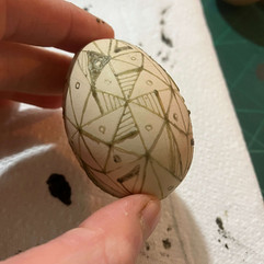 making pysanky. An egg covered in a beeswax pattern ready for dipping in to dye