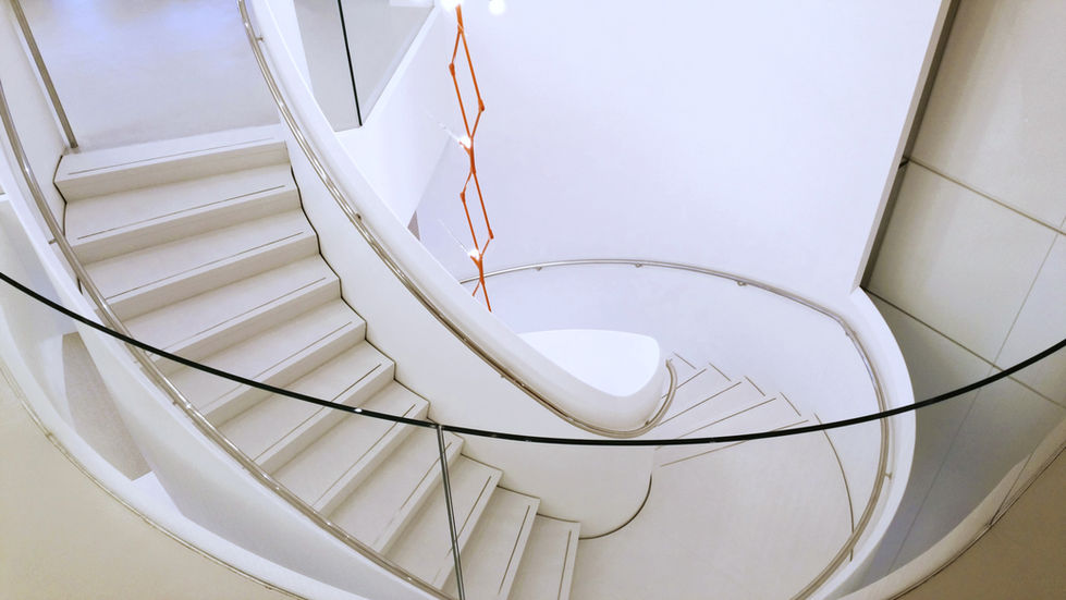 Modern white spiral staircase with glass railing