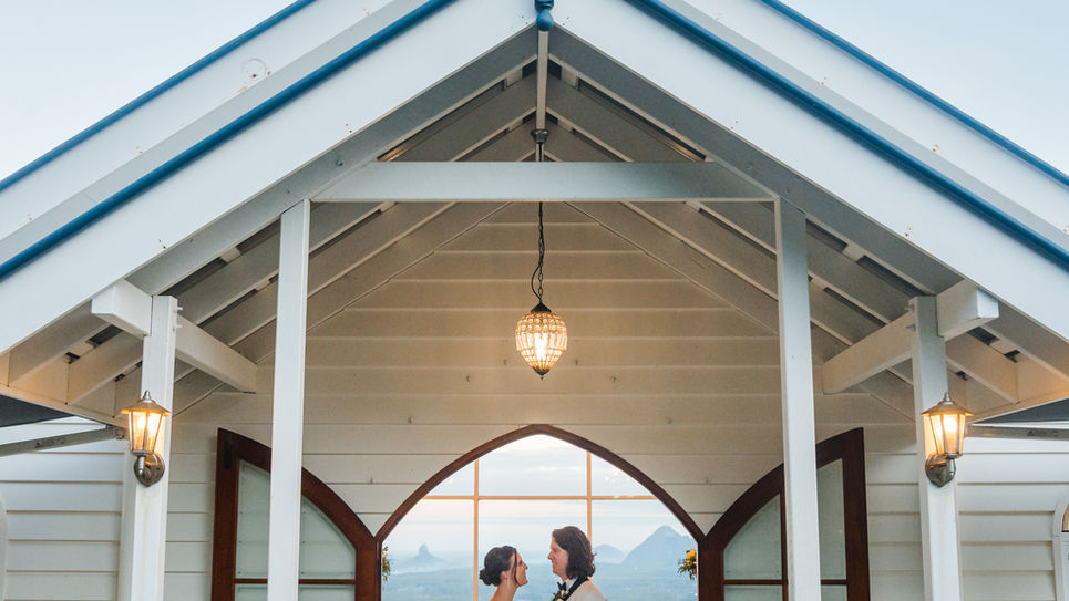 Wedding couple in doorway of wedding chapel, on sunset with the lights on