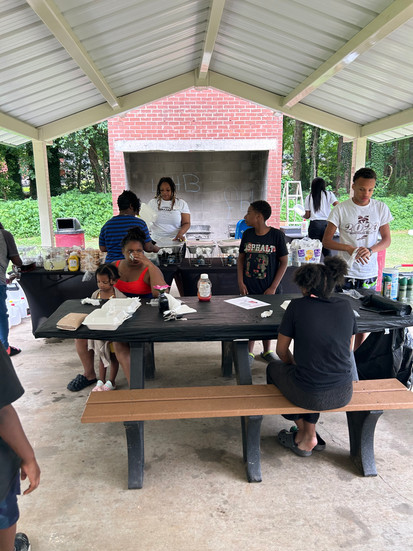 People enjoying their food and talking under the pavilion.