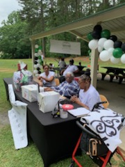 Volunteers sitting at the sign-in table to assist the community.