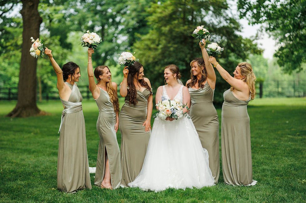 The bride and bridesmaids celebrate by waving their bouquets.