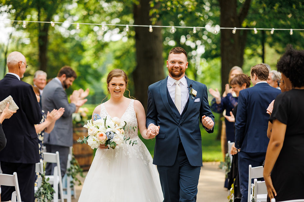 The bride and the groom look at the camera excited as they walk down the aisle as husband and wife.