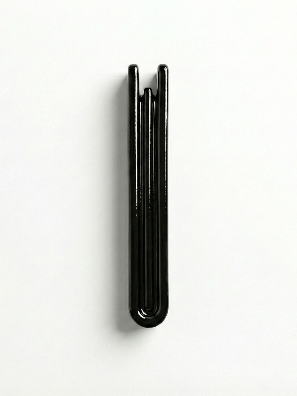 Vertical black Mezuzah Case | Shin on white background, minimalist design.