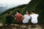4 men joined together in laughter on a hillside