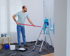 masaking-blue-paint-with-roller-brush-dipped-white-paint-handyman-renovating-apartment-red