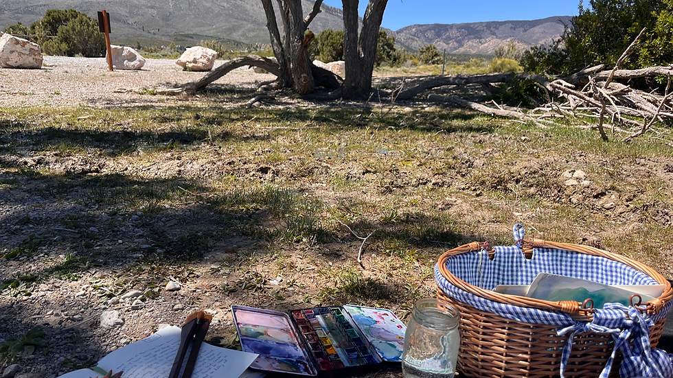 Picnic with journal and watercolor paints under tree in nature