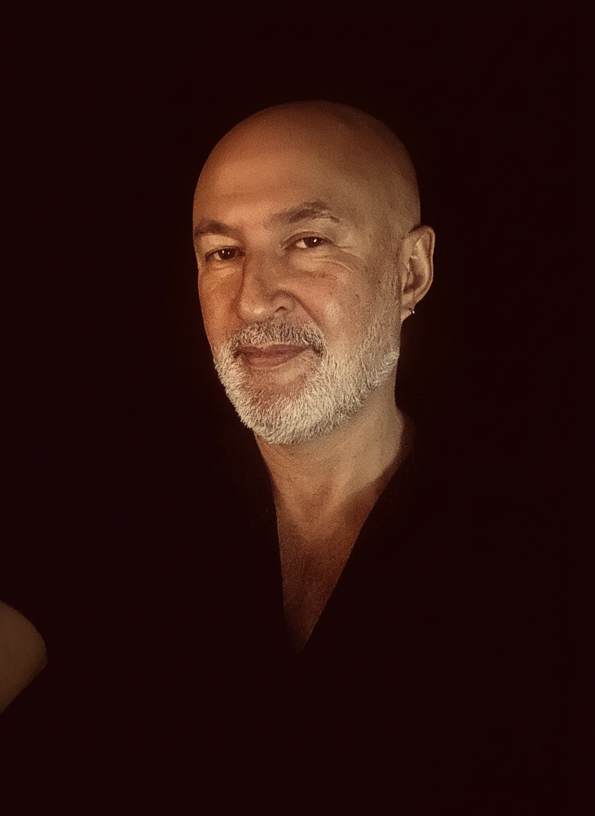 Portrait de Rephaël sur fond sombre, couleurs chaudes, format vertical, visage centré.
