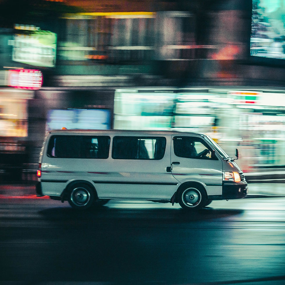 A white van speeds along a road at night.