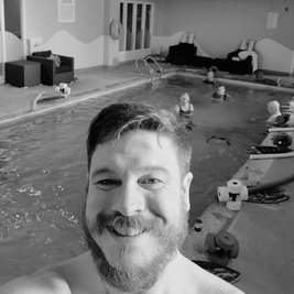Greg at aquafit, participants in the pool in the background.