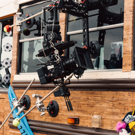 Heavy-duty professional camera rig attached to a vehicle window using suction cups and stabilization arms for tracking shots.