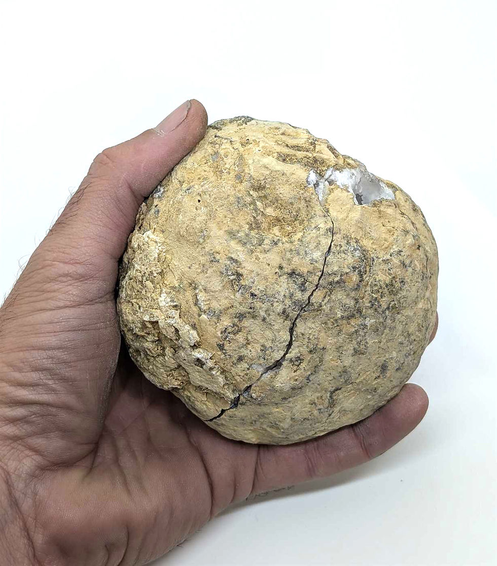 vue de face d'une géode de quartz fermé tenu par une main