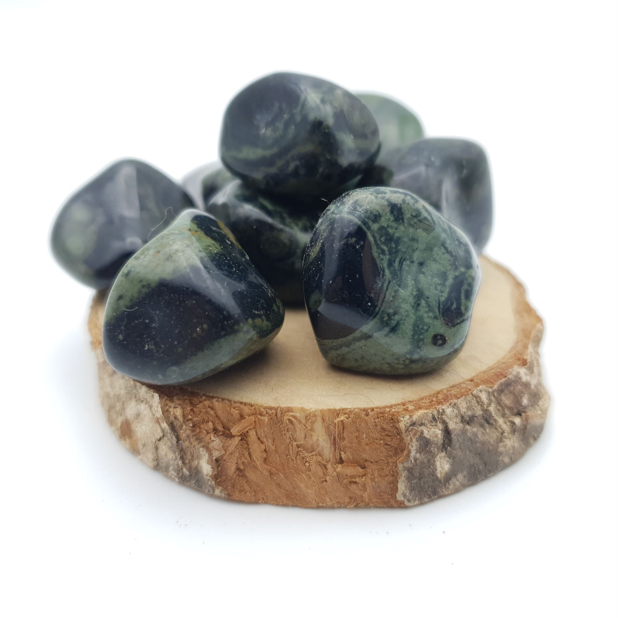 Pierre roulée en jaspe kambaba, posée sur un support en bois rustique vue de face