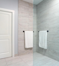 Custom walk-in shower with frameless glass, matte black fixtures, and floor-to-ceiling tile detailing.