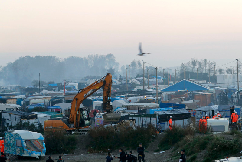 A bulldozer is used to remove debris as workmen tear down makeshift shelters during the dismantlement of the camp called the ‘Jungle’ in Calais, France, October 27, 2016. — Reuters pic.