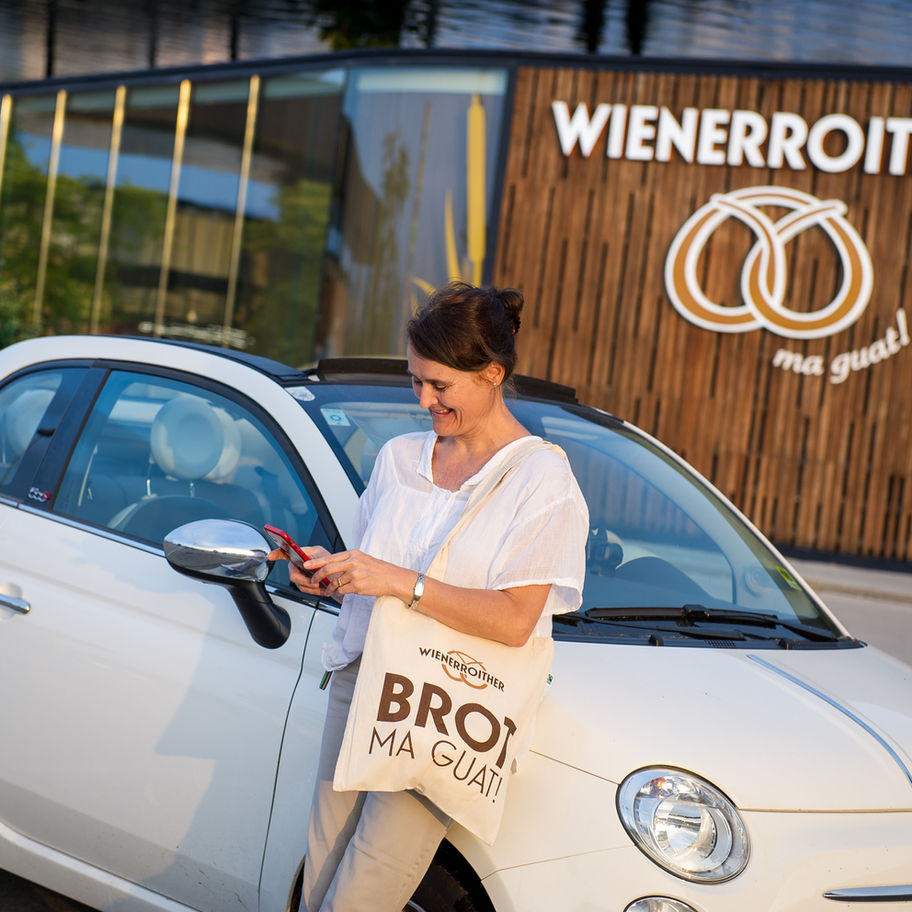 Frau vor Wienerroither Gebäude mit Brezellogo