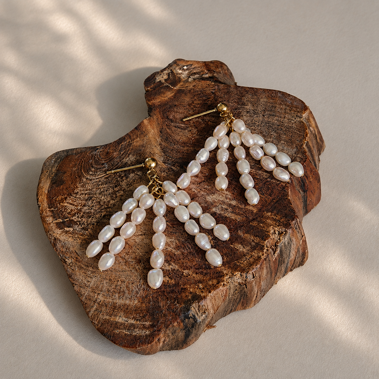 Rivulet freshwater pearl tassel earrings with multi-strand rice pearl drape on wood display