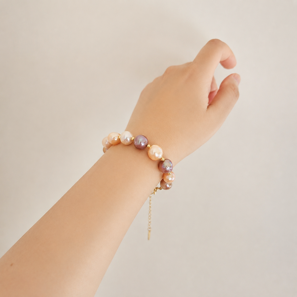Multicolor Edison pearl bracelet with peach and mauve tones worn on the wrist against a neutral background