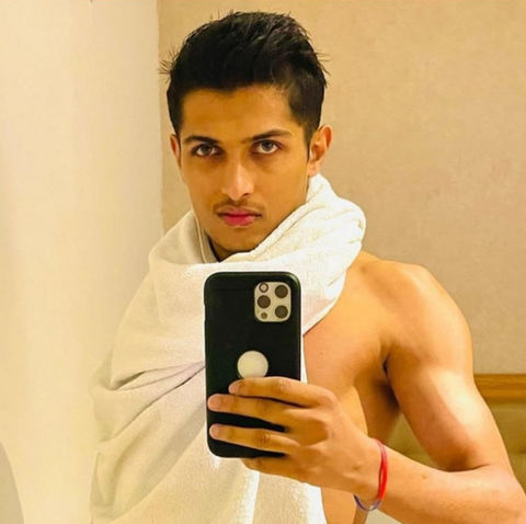 Young man taking selfie, shirtless with towel