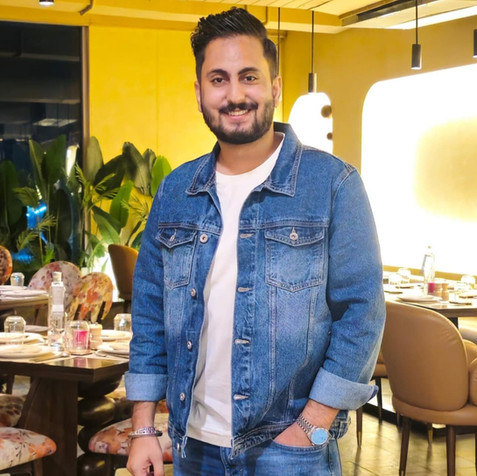 Smiling man in denim jacket with hands in pockets