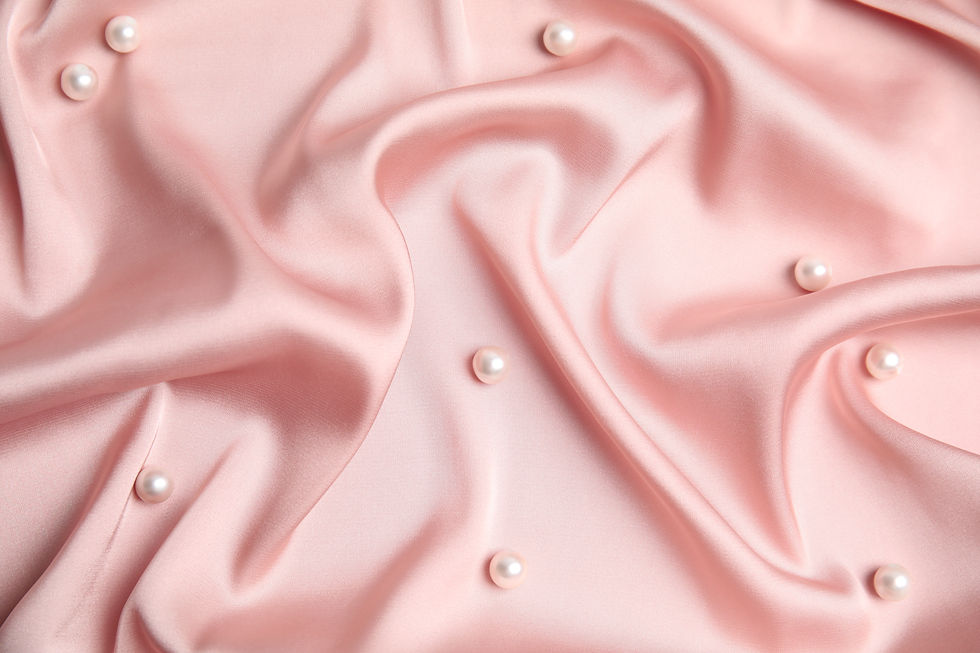 Many beautiful pearls on delicate pink silk, flat lay.jpg