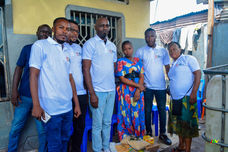 Afro Innovation Group staff standing with local residents during a household visit in the DRC.