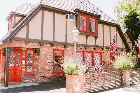 Hamlet Inn, exterior of the building. Cottage with vibrant red window panes offsetting brick building.