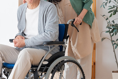 男性の車いすを介助する女性