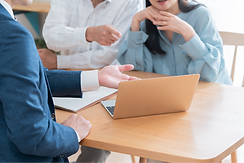 パソコンを見せて説明するビジネスマン