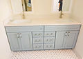 Custom bathroom vanity with light blue-gray cabinets, double sinks, quartz countertop and brushed metal hardware