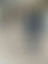 a man in a blue longsleeve shirt and blue pants stands with his arms crossed next to a child