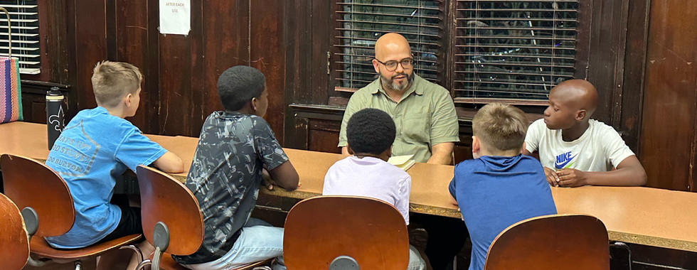 students at table talking to an adult