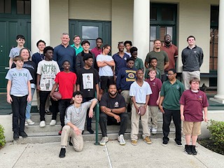 a group of people pose on the steps in front of a building