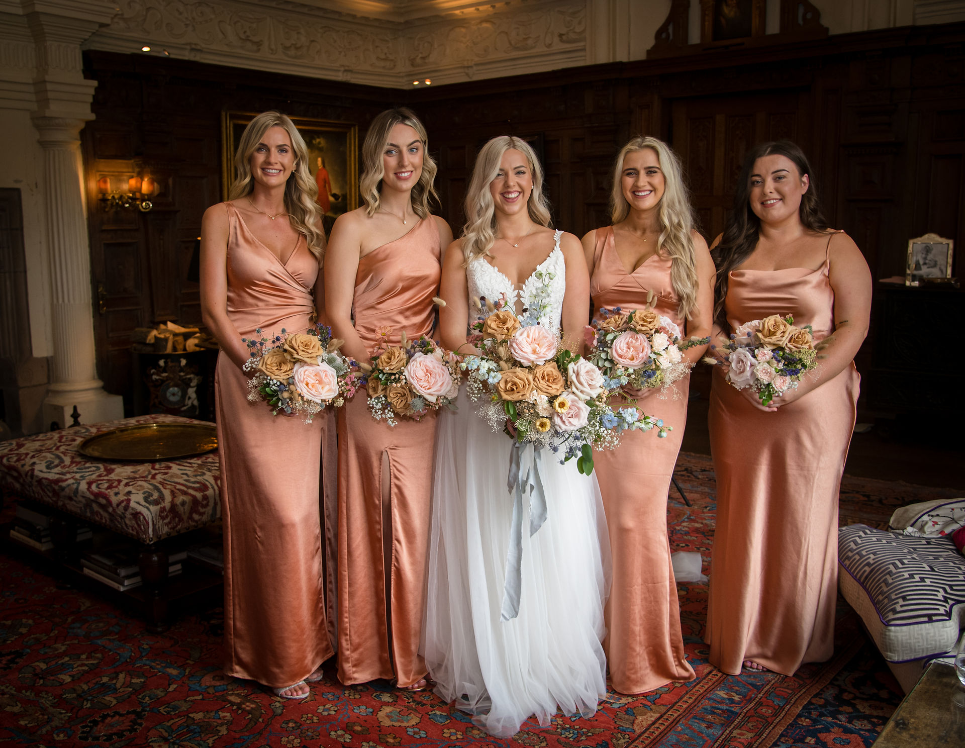 Bride and bridesmaids with their bouquets of 'Quicksand' roses,baby's breath, 'toffee' roses and 'Dewi Boy' delphiniums