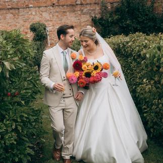 Bride and groom with her bouquet of dahlias, zinnia and sunflowers