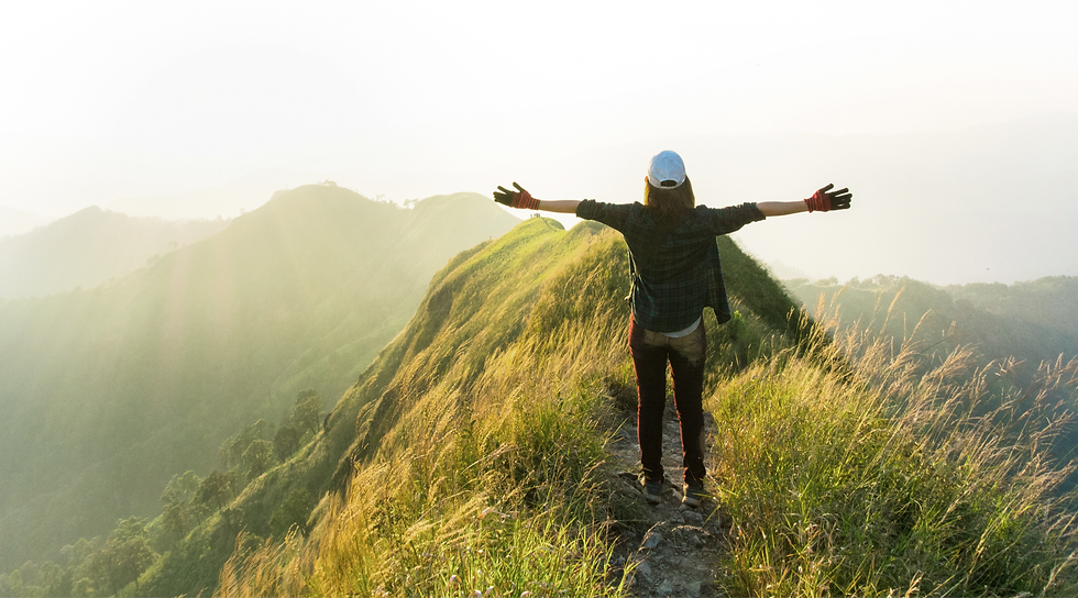 Woman with arms open to open sky and a wide horizon