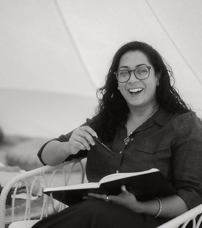 Holistic therapist laughing in her healing space, creating a welcoming yet professional environment for deep healing