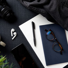 a table with many elementes: coffee, glasses, photography, notebook...