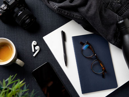 a table with many elementes: coffee, glasses, photography, notebook...