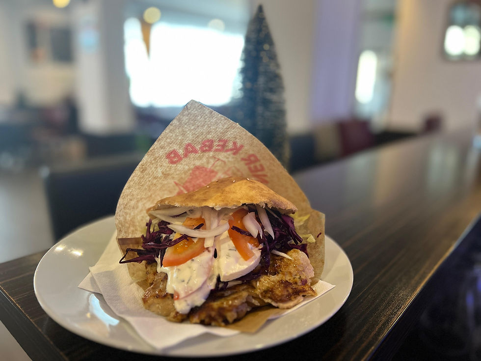 Frischer Döner Kebab BABAY mit Fleisch, Gemüse, Sauce im Restaurant.