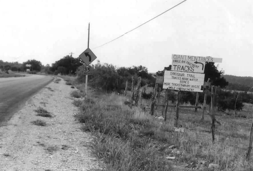 McFall's sign with entrance to Wilkins farm in background where road curves. Taken in 1968.