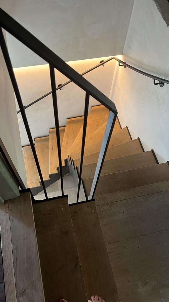 eiken trap met metalen wangen en muurleuning